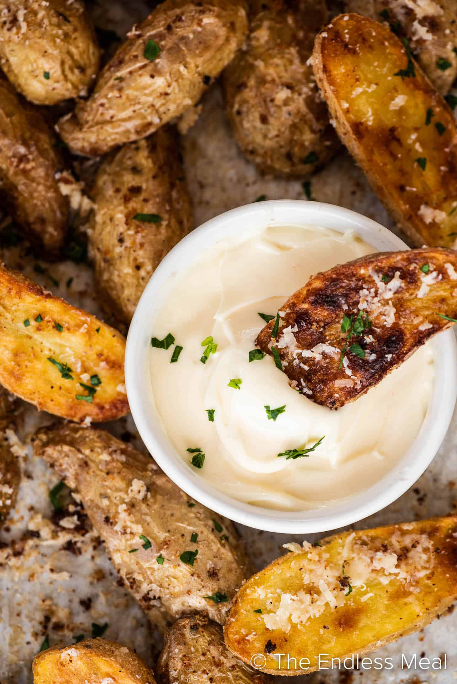 a Roasted Fingerling Potato being dipped into mayo