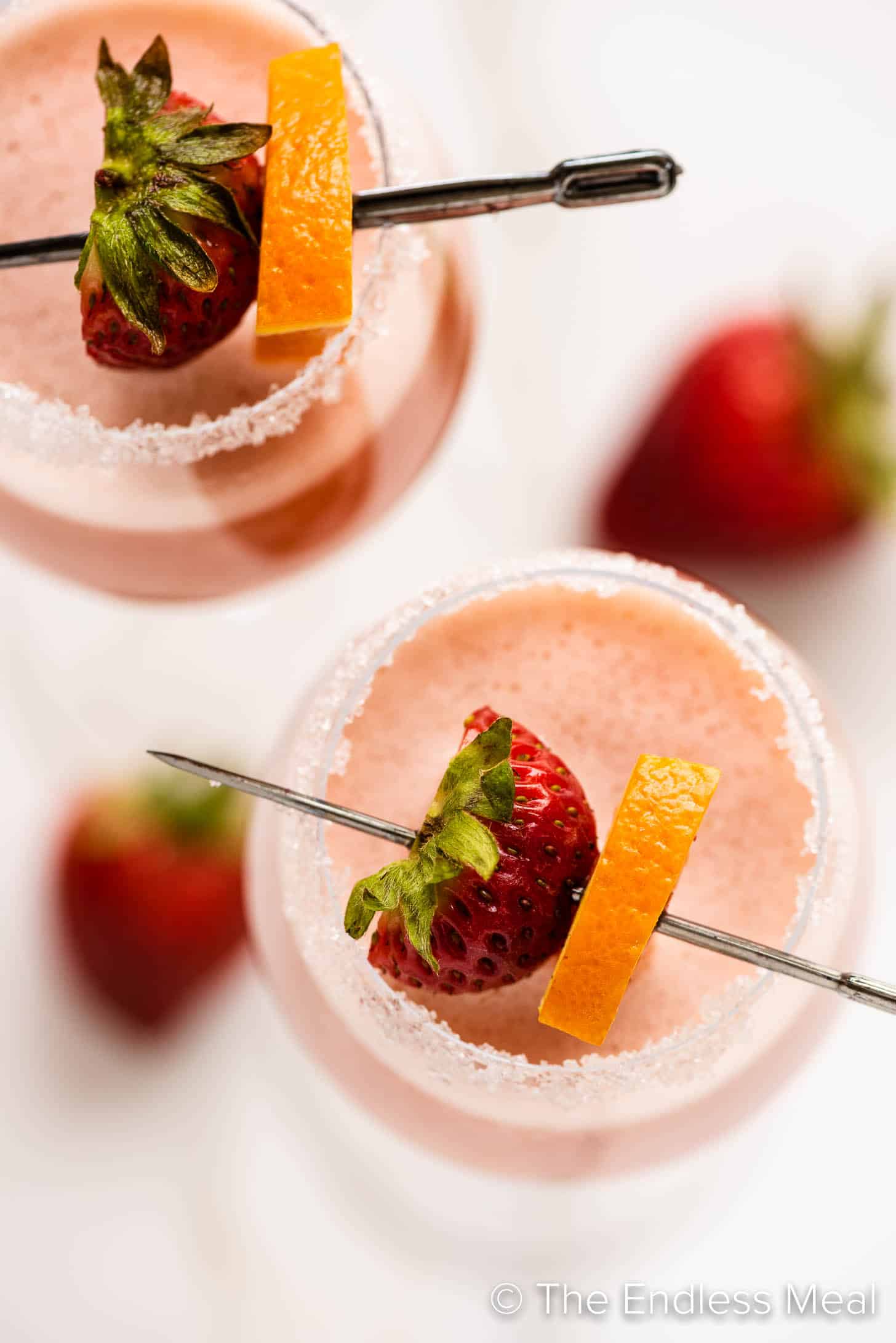Strawberry Mimosa in a champagne flute with strawberries and an orange slice