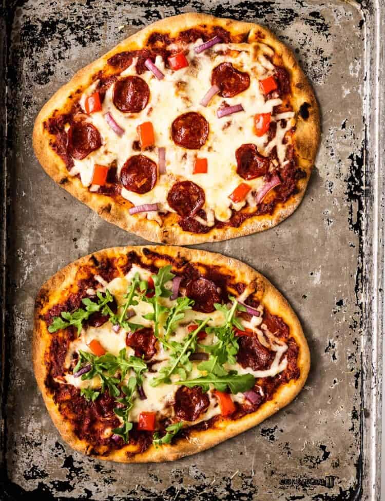 two Naan Pizzas on a baking sheet