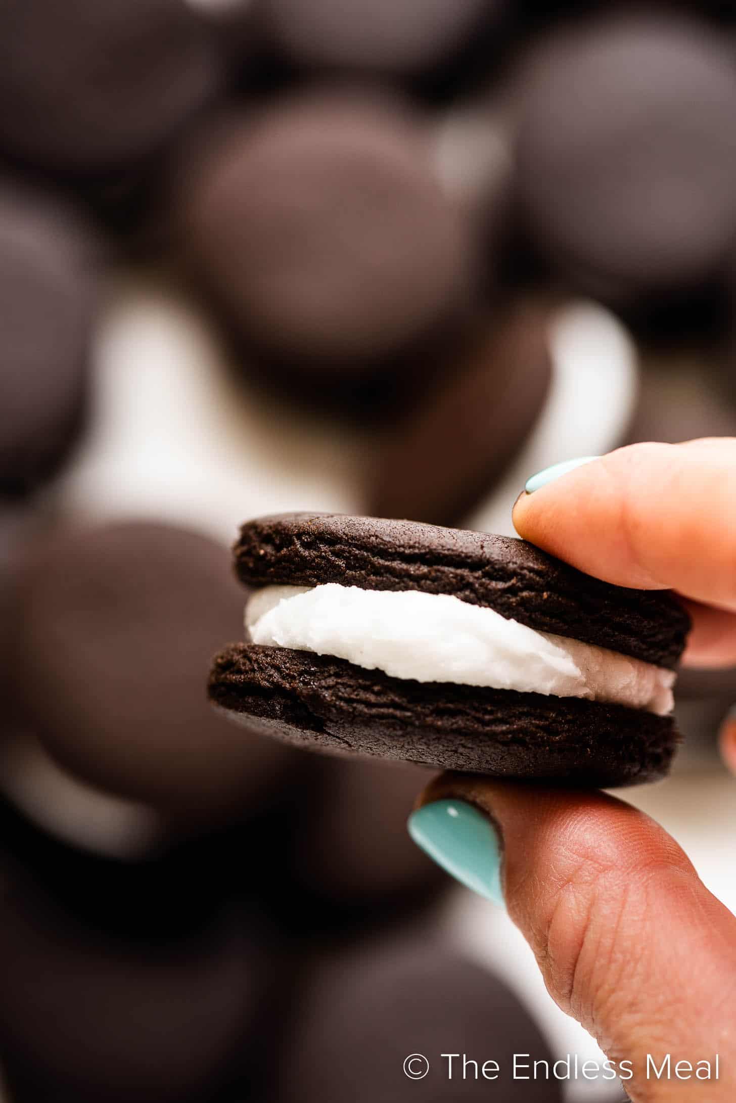 a hand holding a homemade Oreo cookie