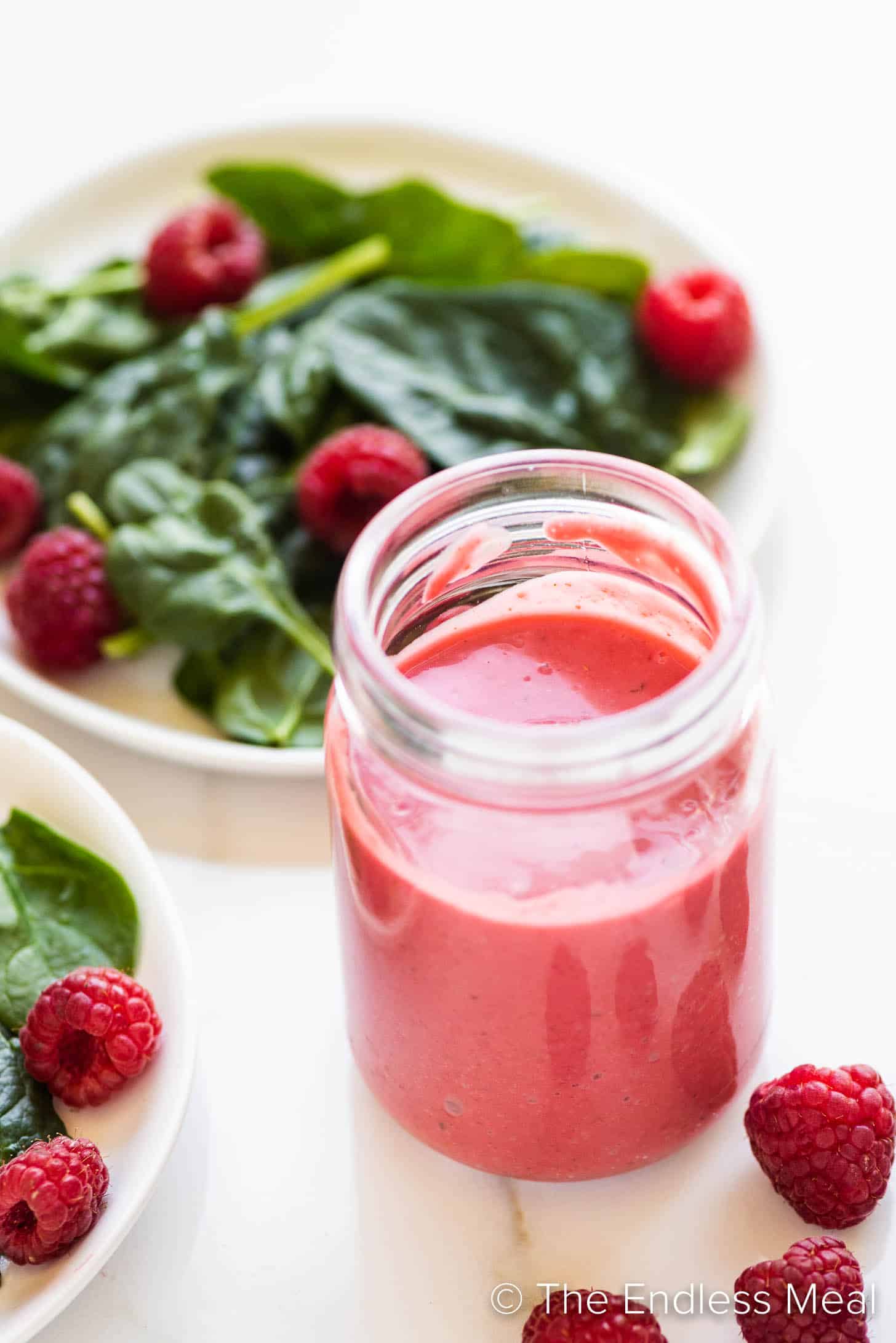 Raspberry Vinaigrette in a jar beside a salad