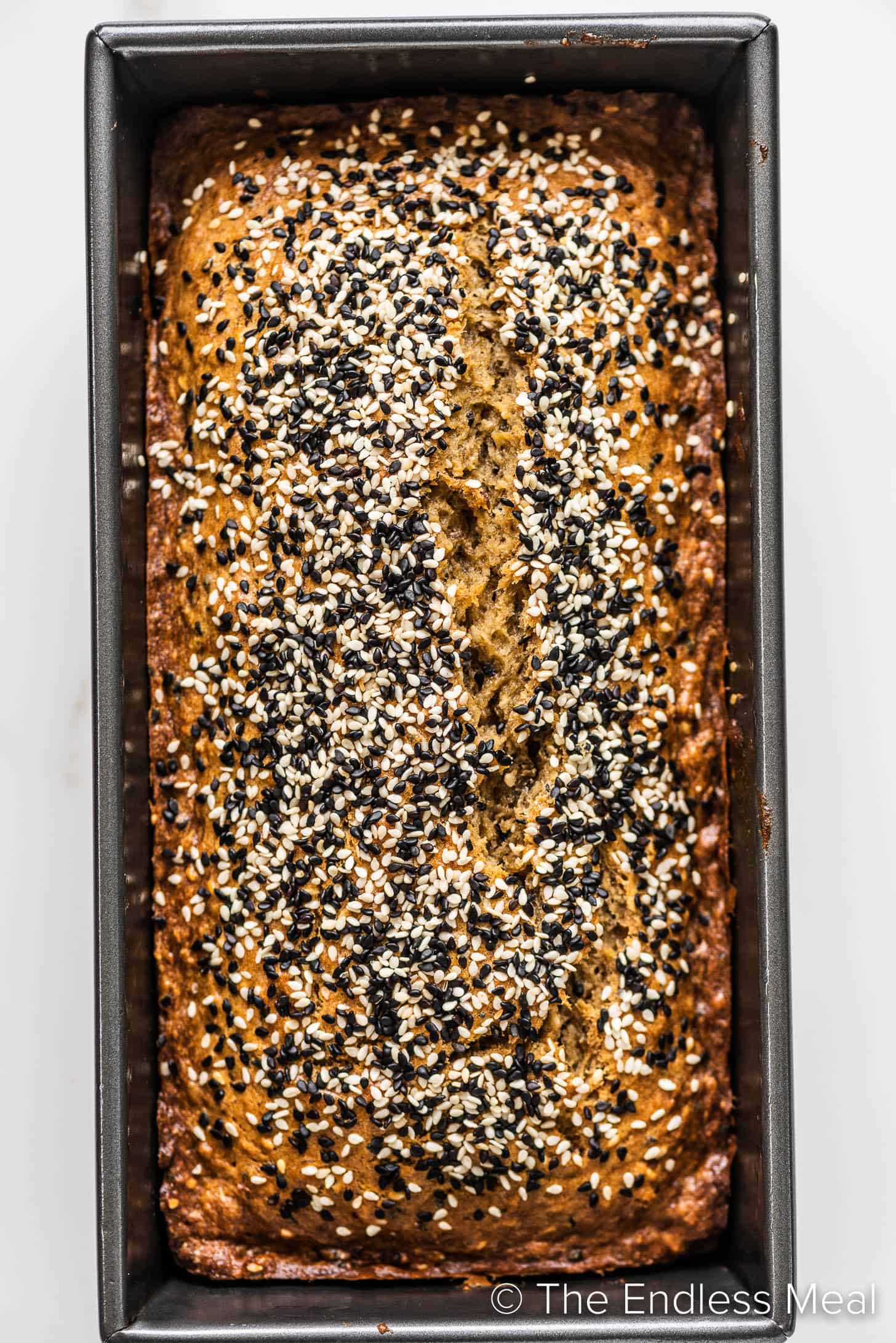 looking down on a loaf of Tahini Banana Bread topped with sesame seeds