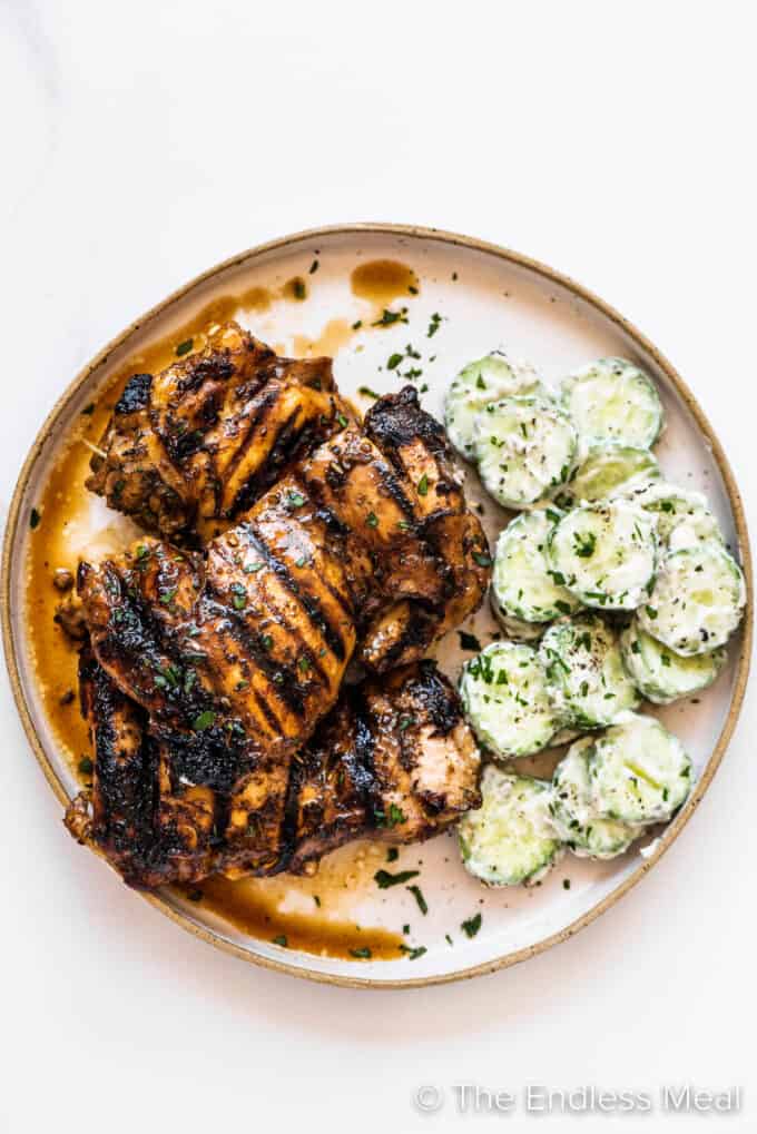 balsamic chicken on a plate with cucumber salad.