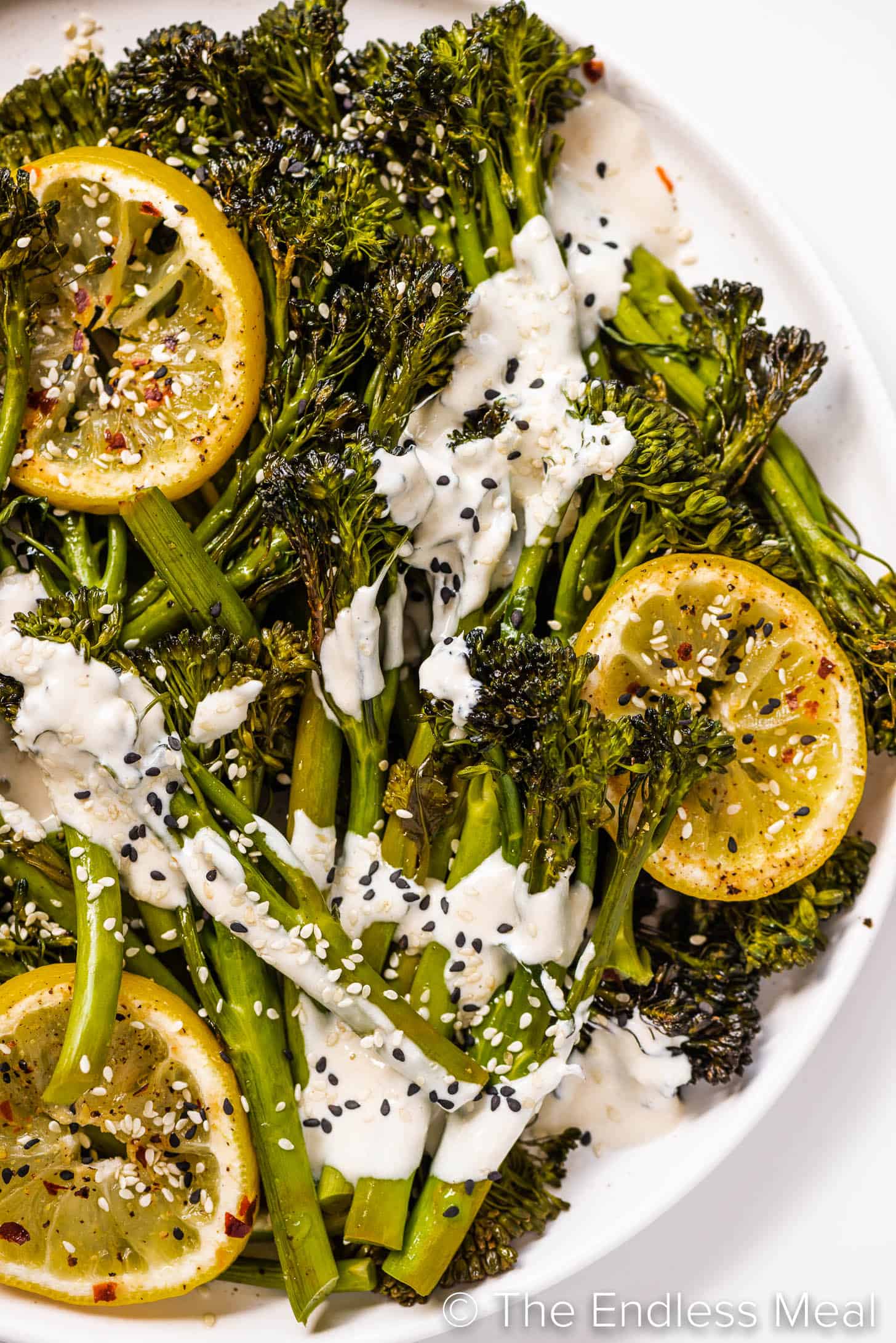 a serving plate with roasted broccolini covered in tahini sauce