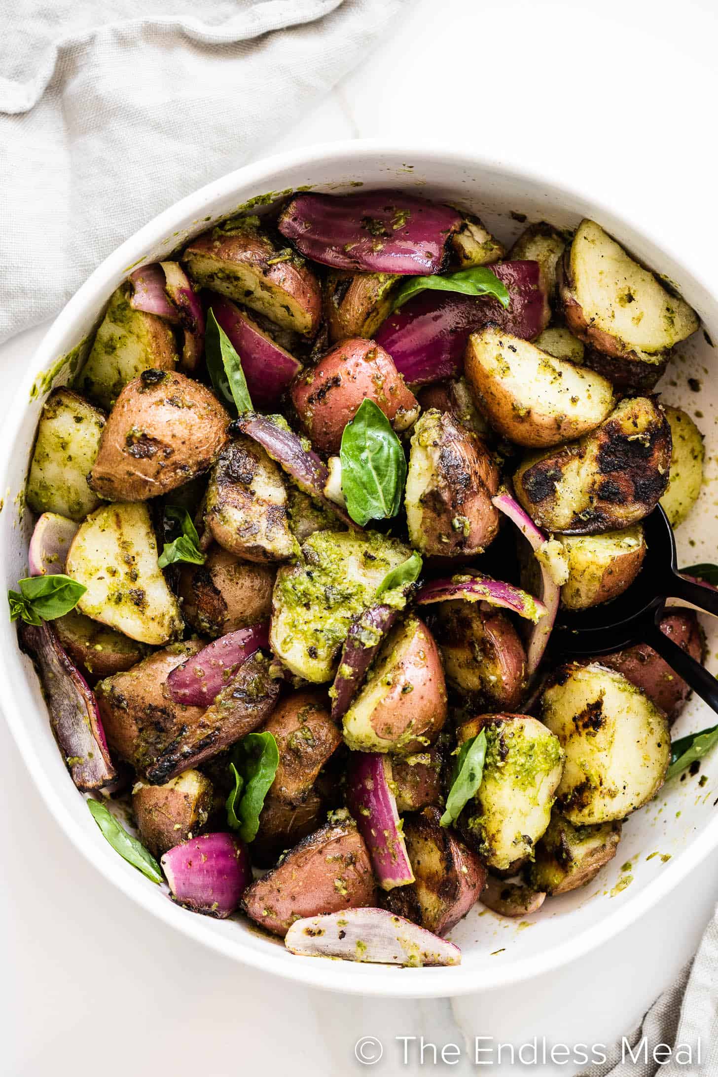 looking down on a Grilled Potato Salad in a white bowl on a table