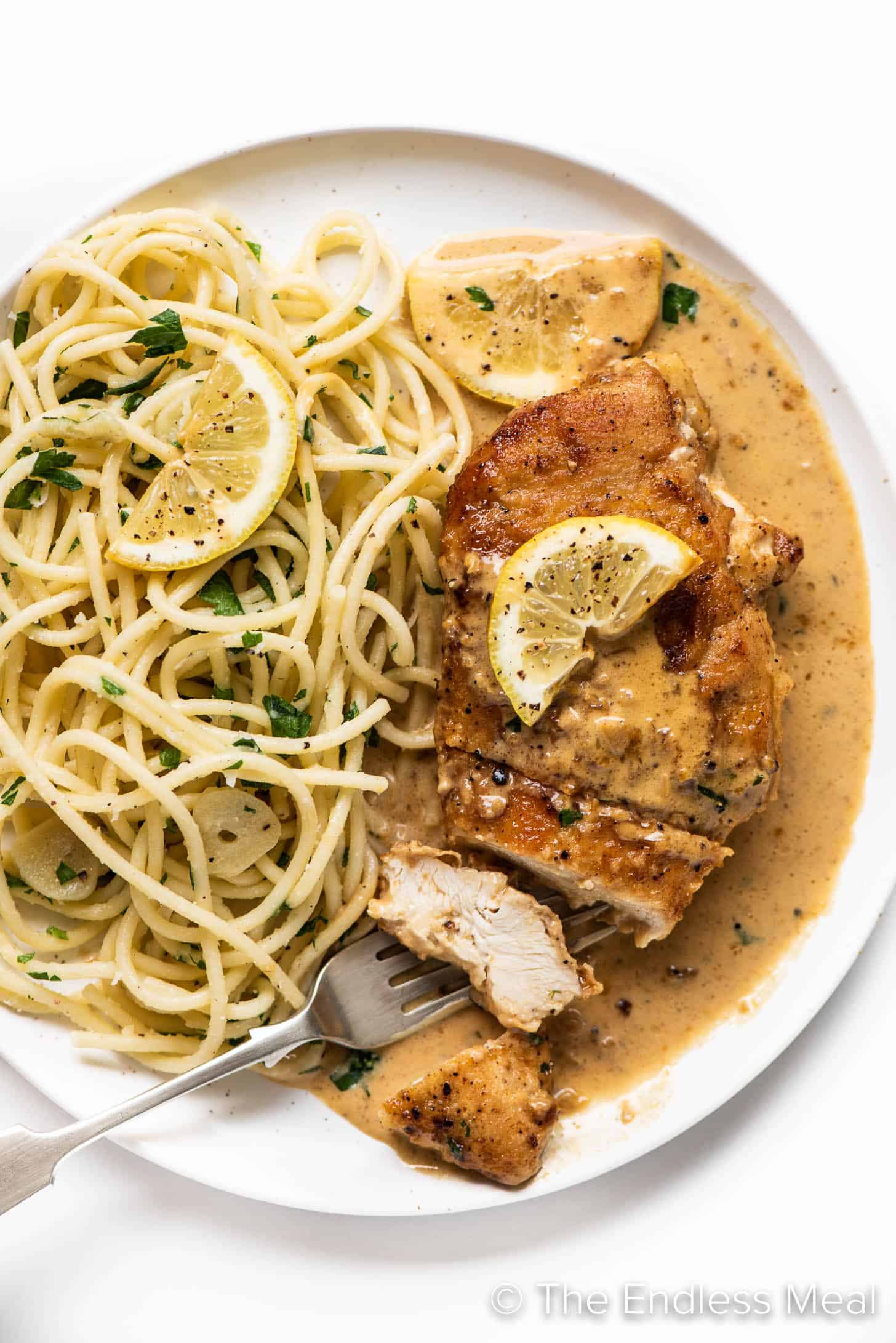 Lemon Pepper Chicken sliced on a plate with pasta covered in creamy sauce