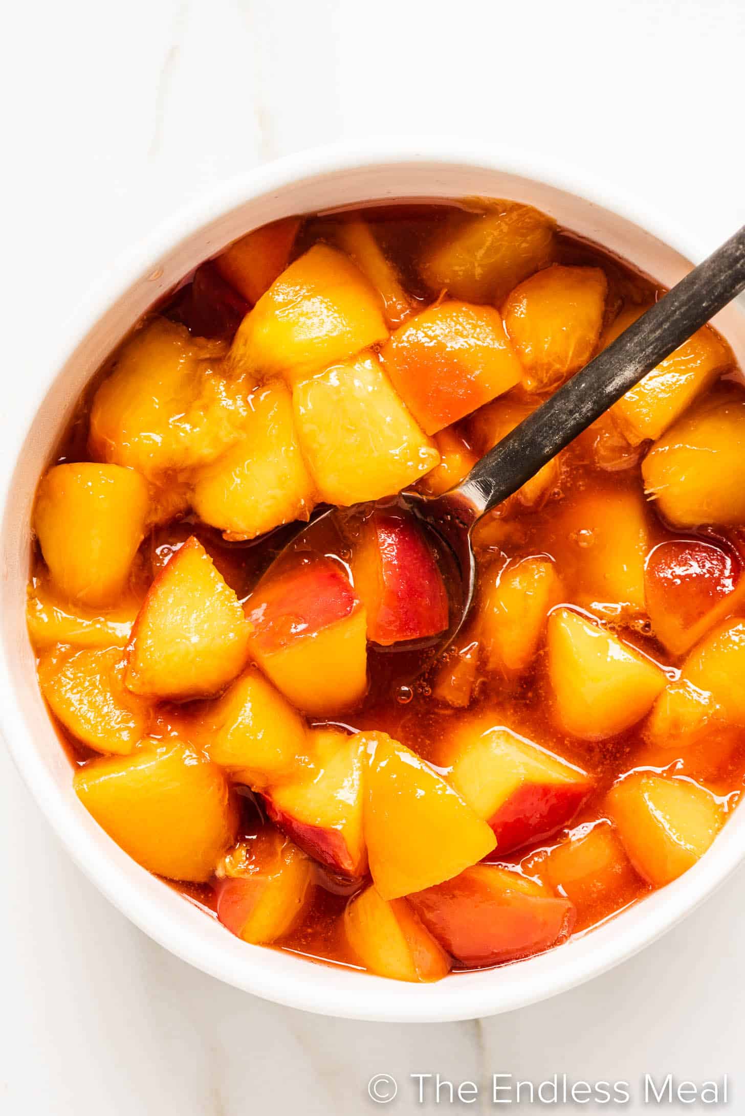 Peach Compote in a bowl with a spoon