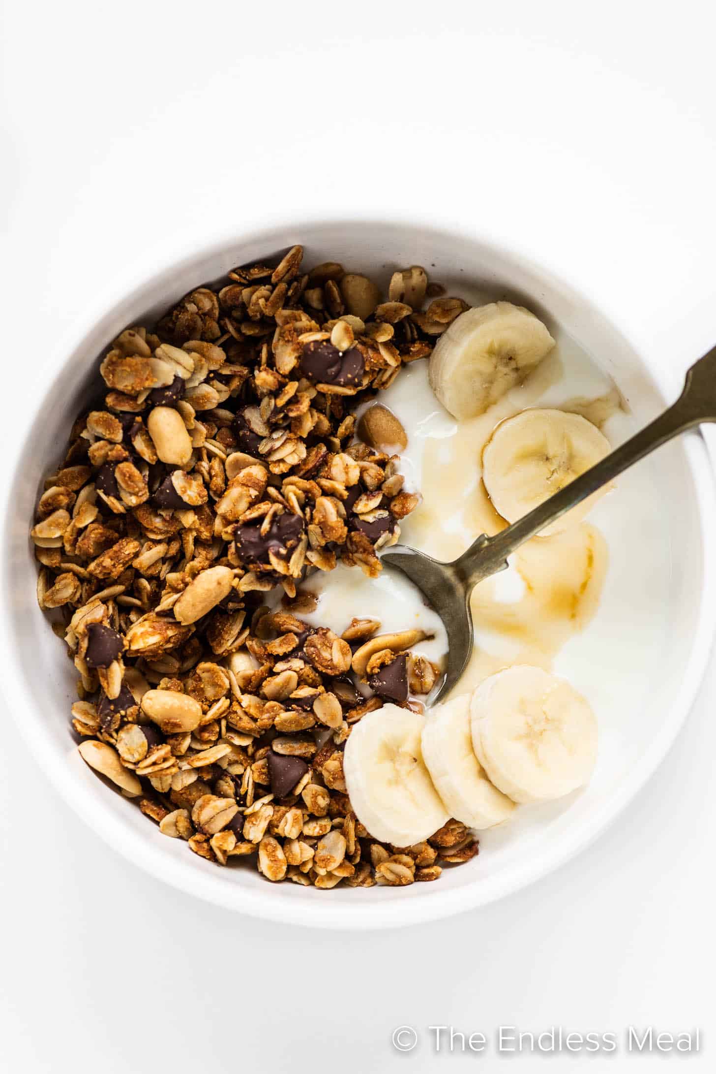 Peanut Butter Granola in a cereal bowl with yogurt and bananas