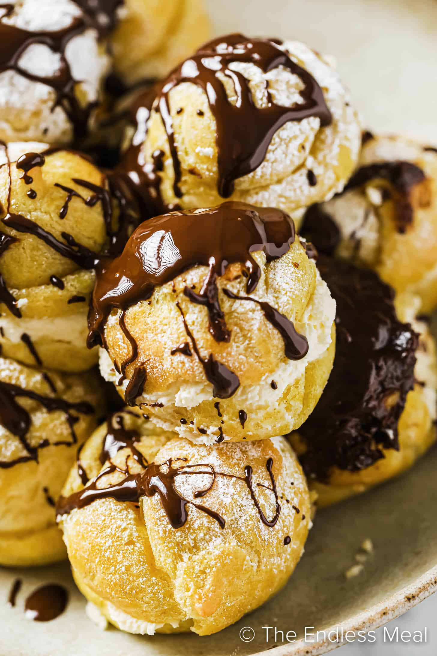 a close up of cream puffs with chocolate sauce