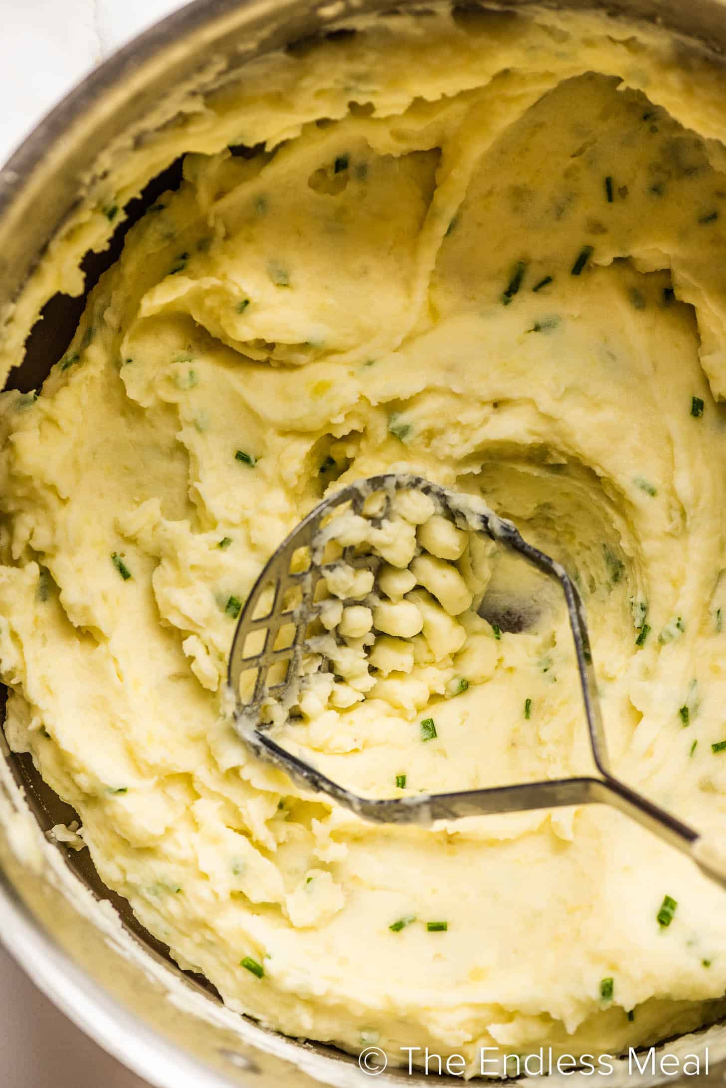 a close up of Sour Cream and Chive Mashed Potatoes in a pot