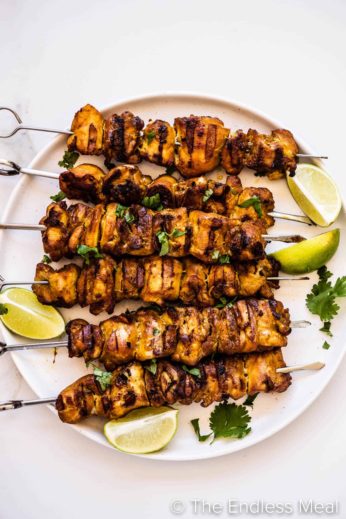 Thai Chicken Skewers on a plate with limes