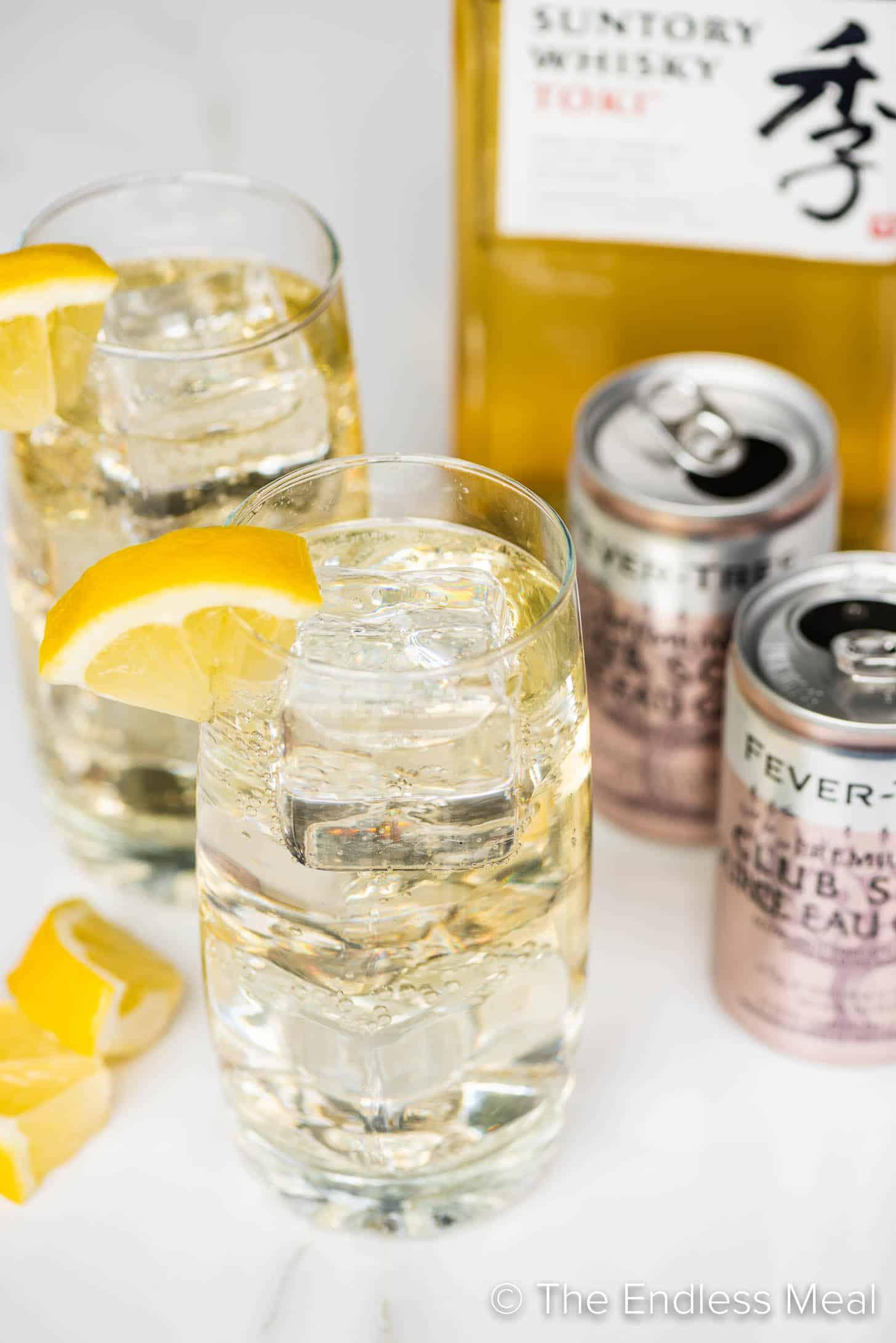 a close up of a whiskey highball next to a can of soda