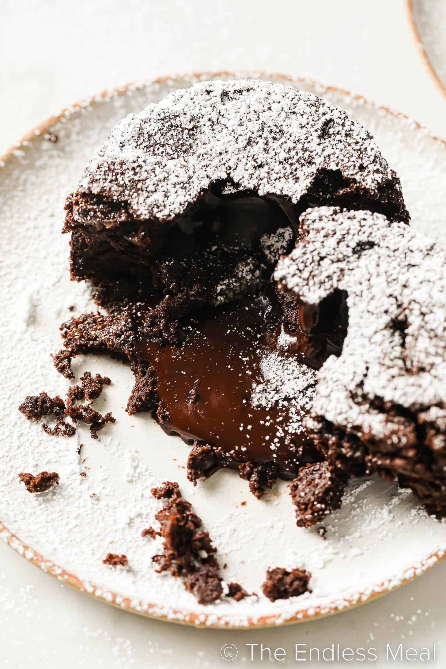 Gooey chocolate lava cake cut open with the inside melting out. 