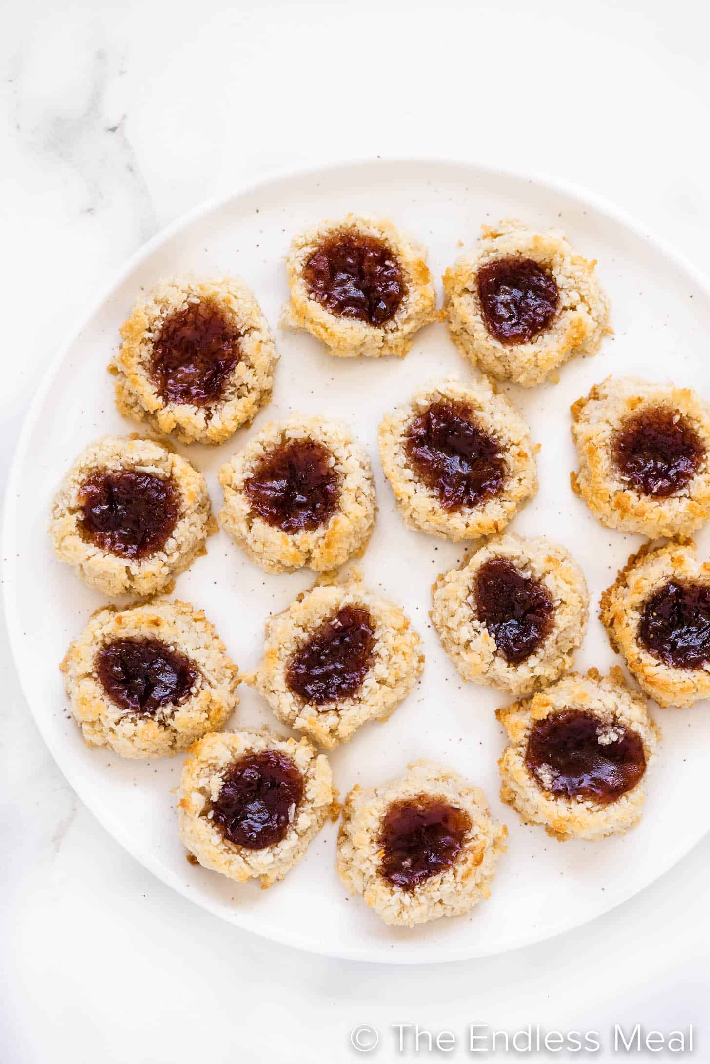 a plate of coconut thumbprint cookies on a plate.