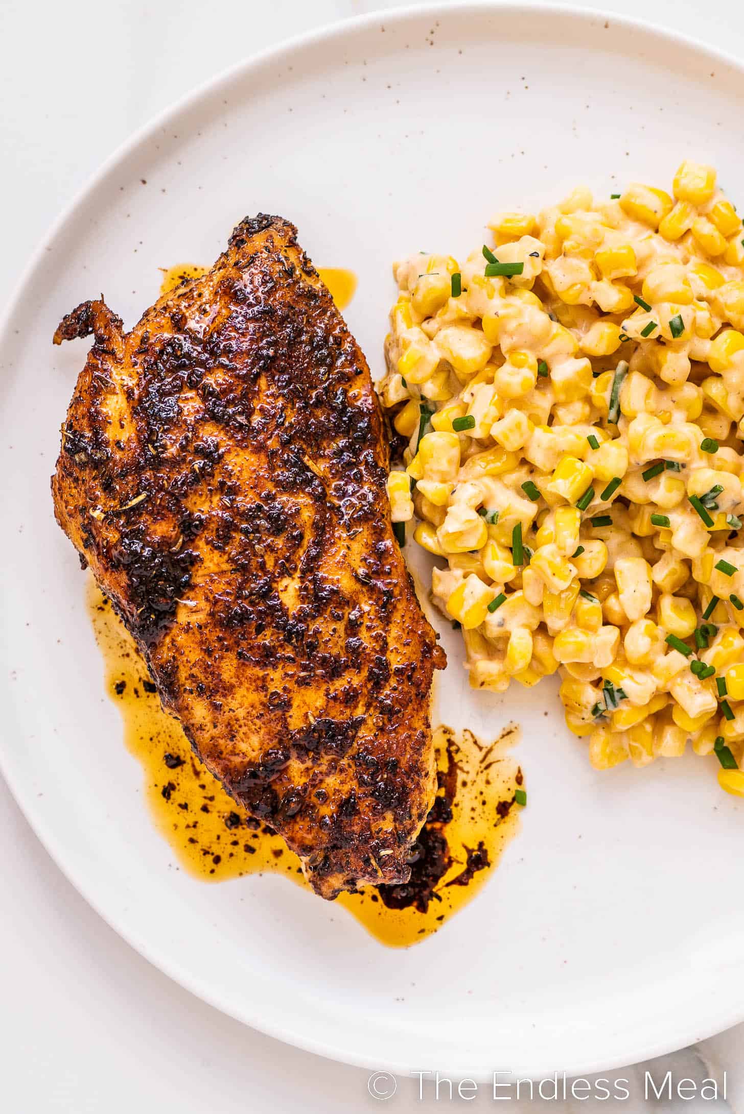 Italian Seasoning Chicken on a plate next to buttered corn