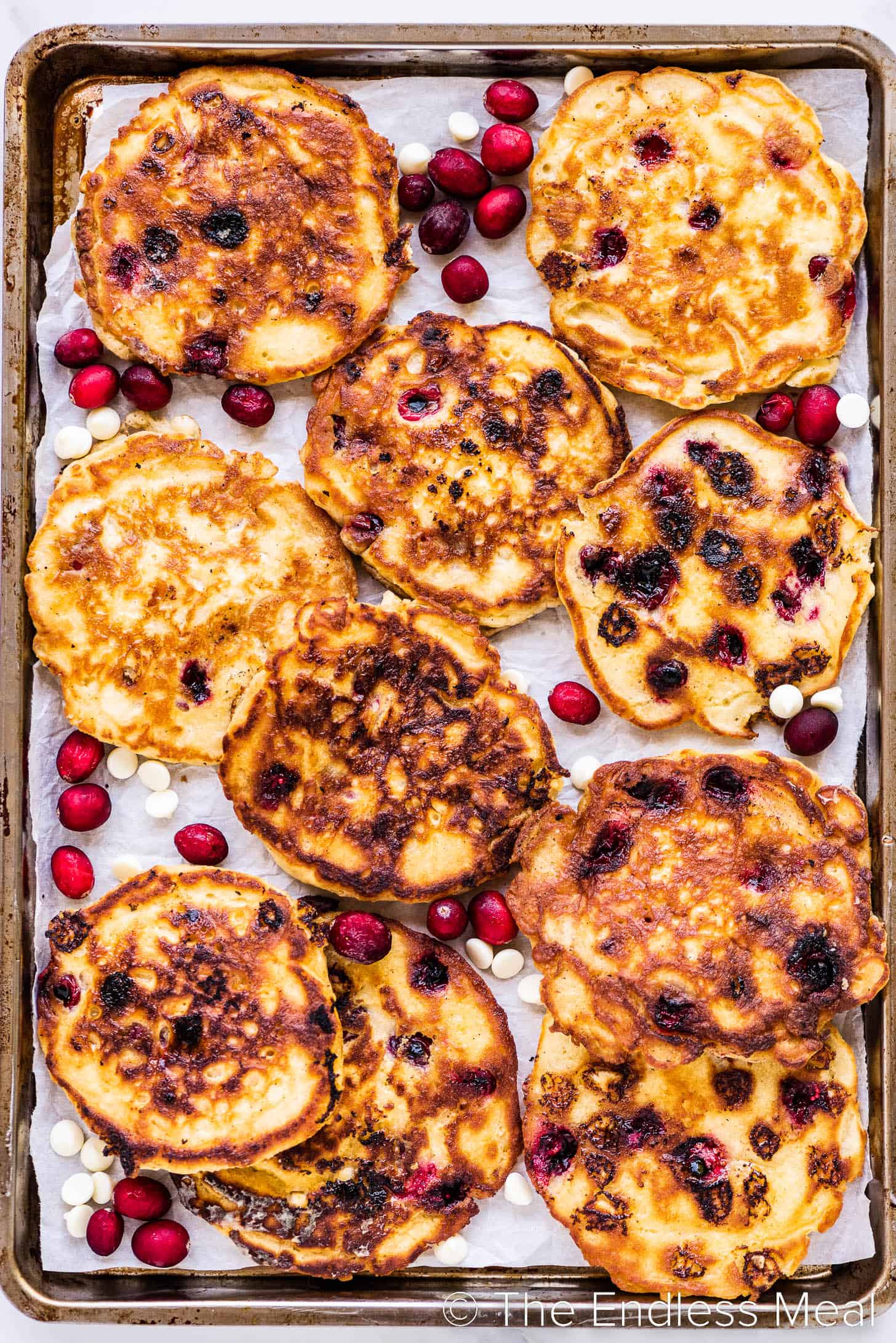 a sheet pan with pancakes with cranberries and white chocolate chips