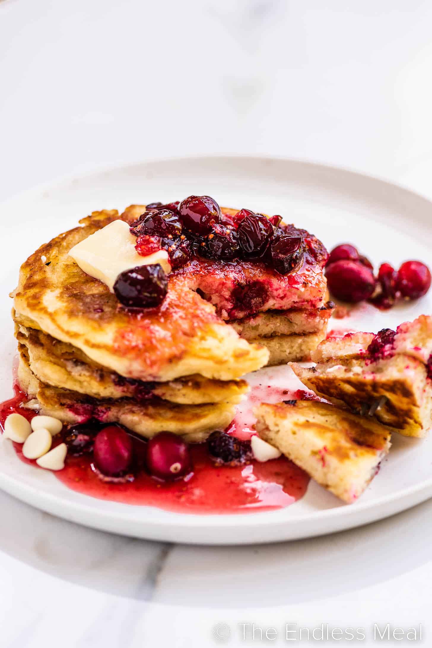 a stack of Cranberry Pancakes with a slice out of them.