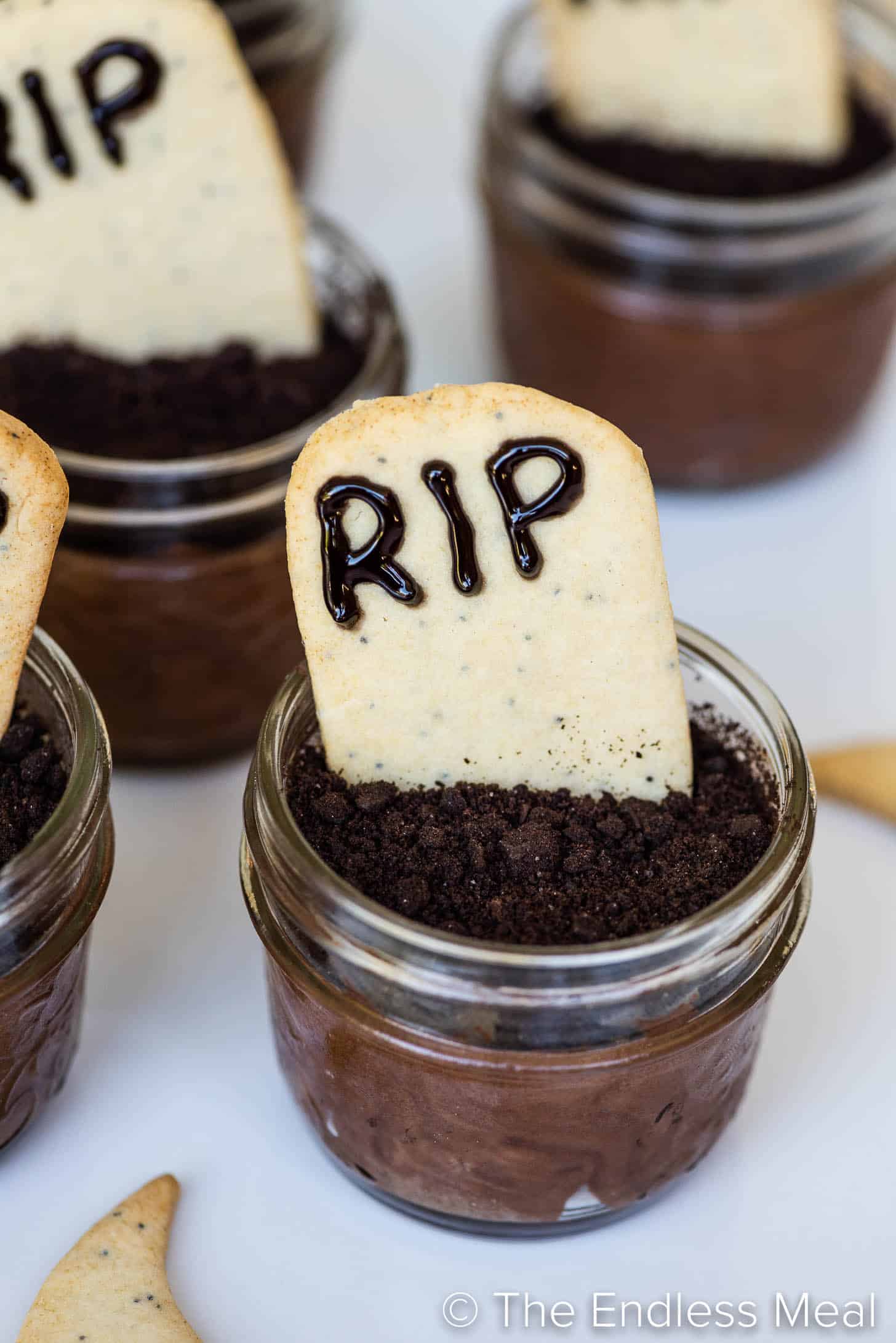 a close up of a tombstone cookie on top of Halloween Chocolate Mousse