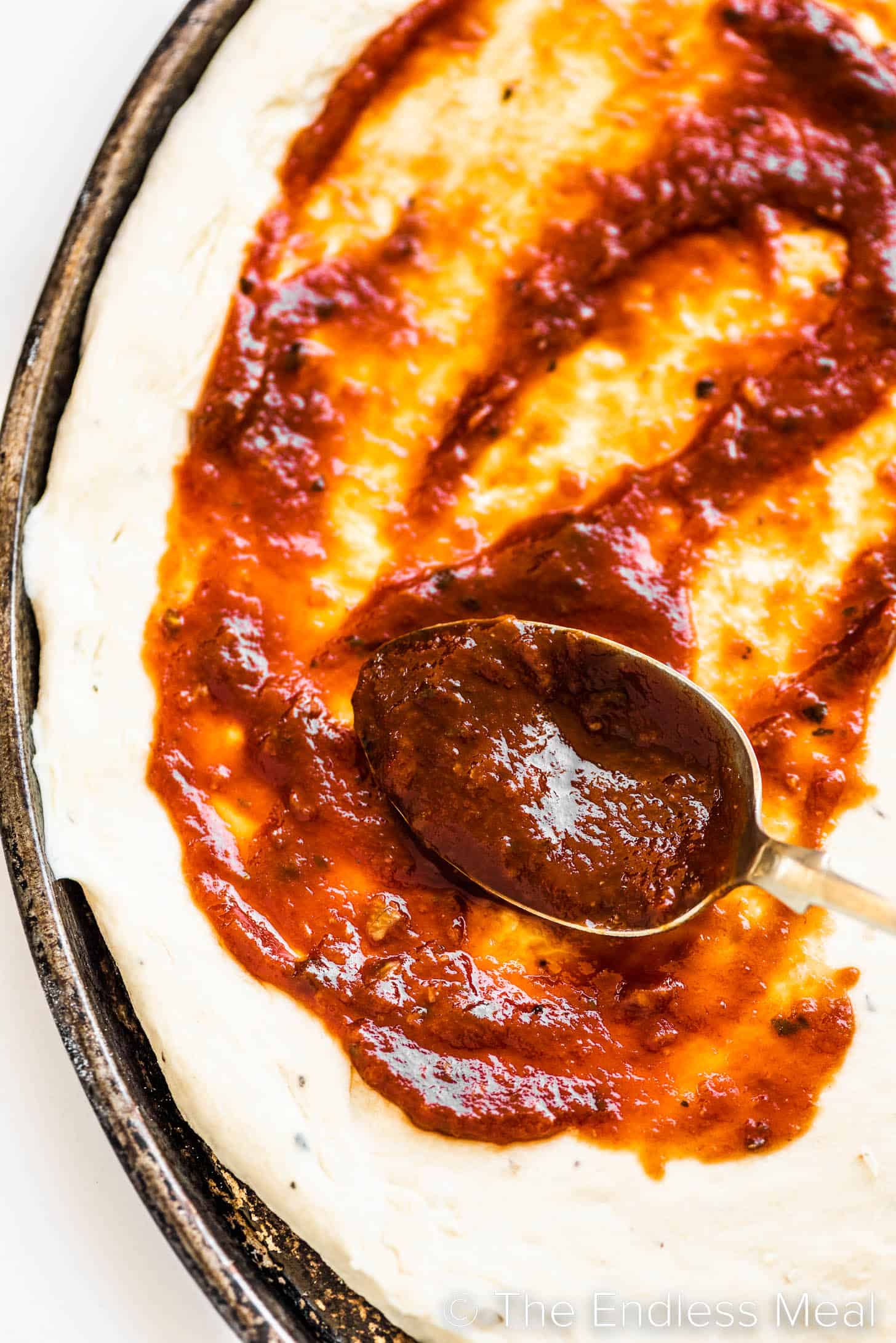 salsa per pizza fatta in casa spalmata su una crosta di pizza