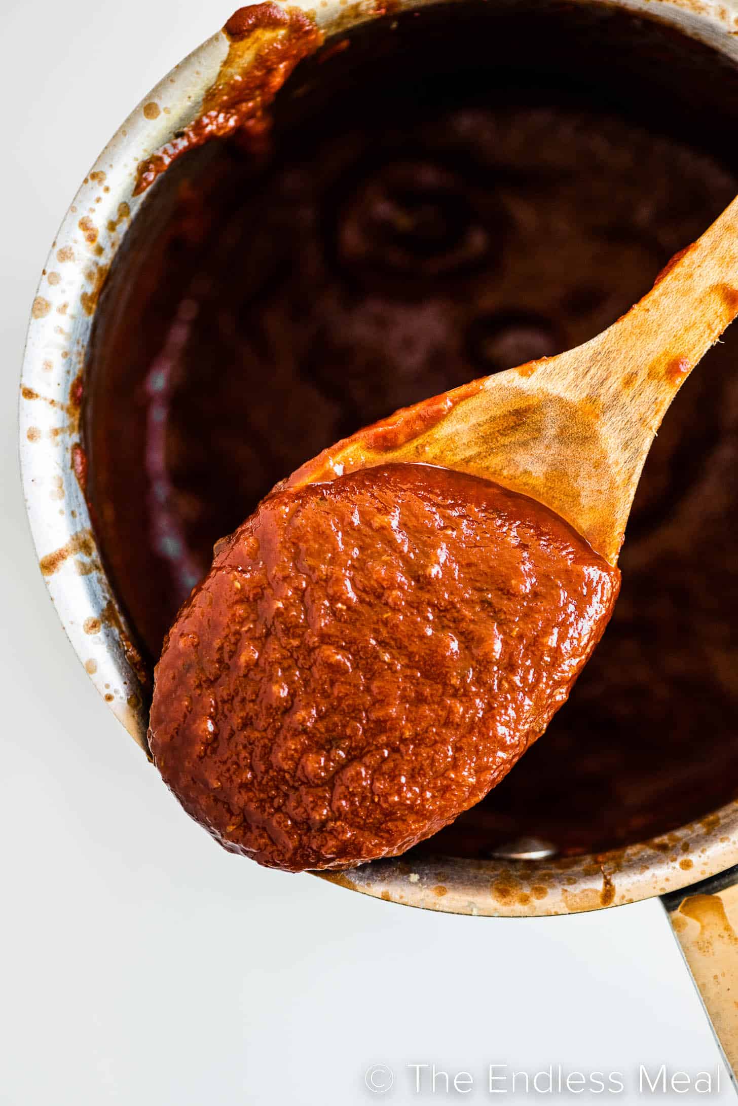 this pizza sauce recipe in a pot with a wooden spoon