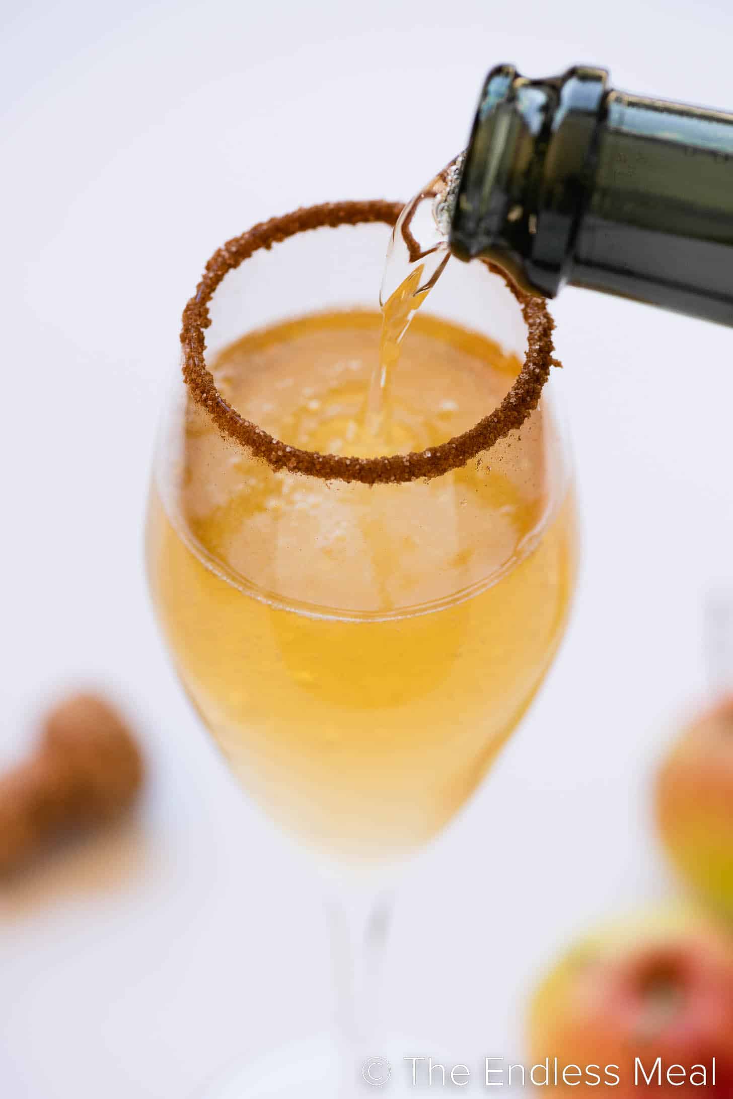 sparkling wine being poured into a champagne flute with apple cider