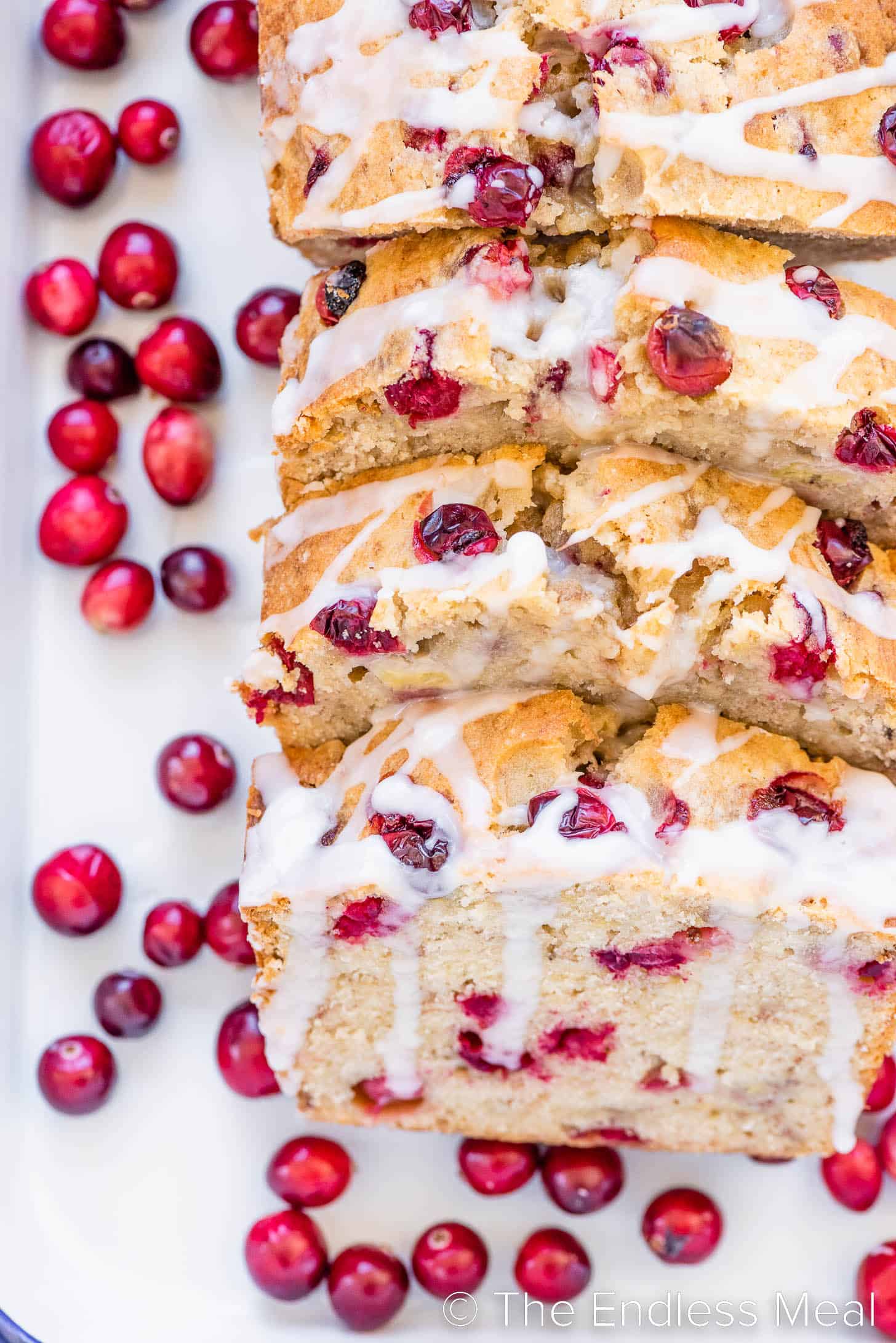a close up of banana bread with cranberries on a serving platter