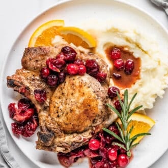 a plate of pork chops with cranberry sauce