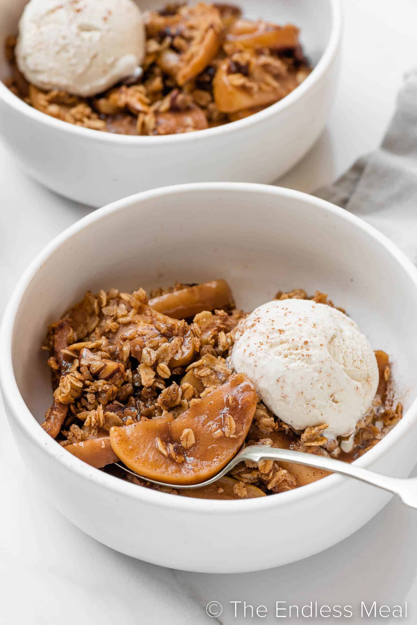 Healthy Apple Crisp in a bowl with ice cream.