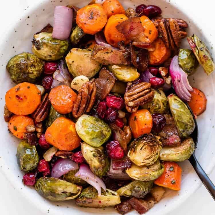 Holiday Roasted Vegetables in a serving bowl with a spoon