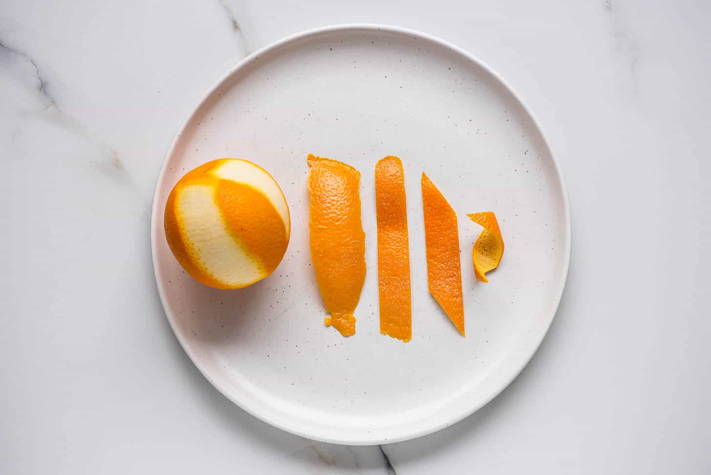 picture showing how to make an orange twist for a cocktail