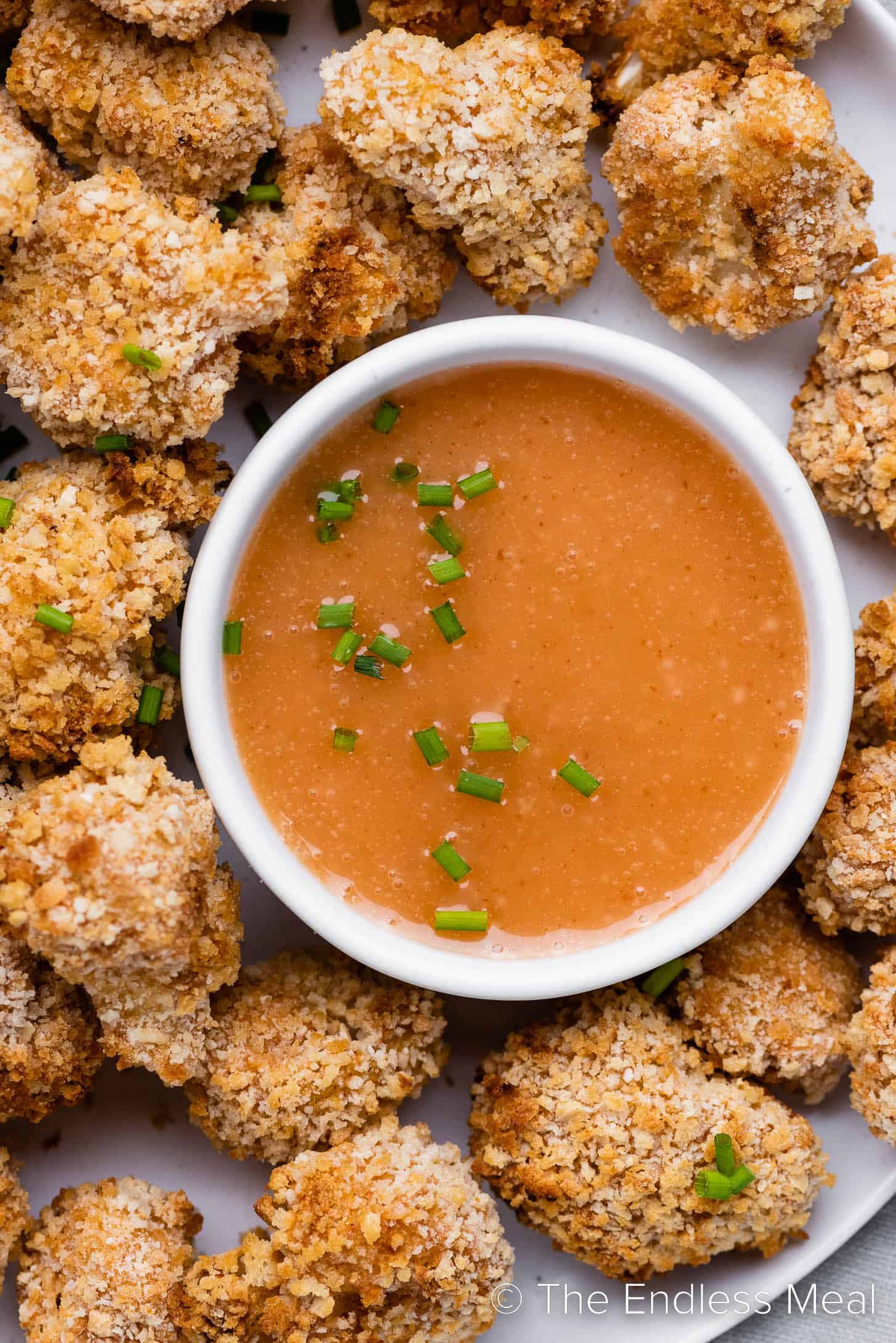 Bang Bang Sauce in a bowl surrounded by crispy cauliflower wings