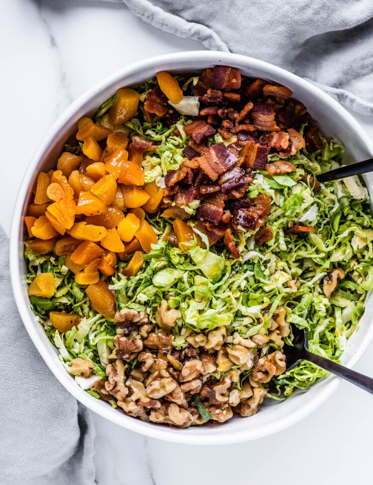 all the ingredients needed to make this Shredded Brussels Sprouts Salad in a salad bowl