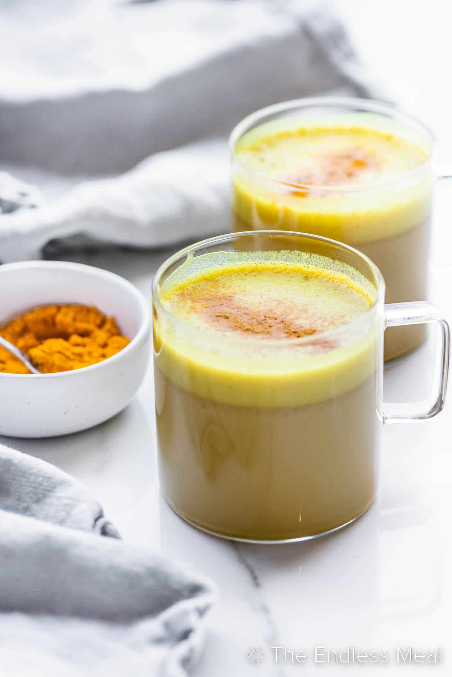 Two Coconut Turmeric Lattes in glass mugs