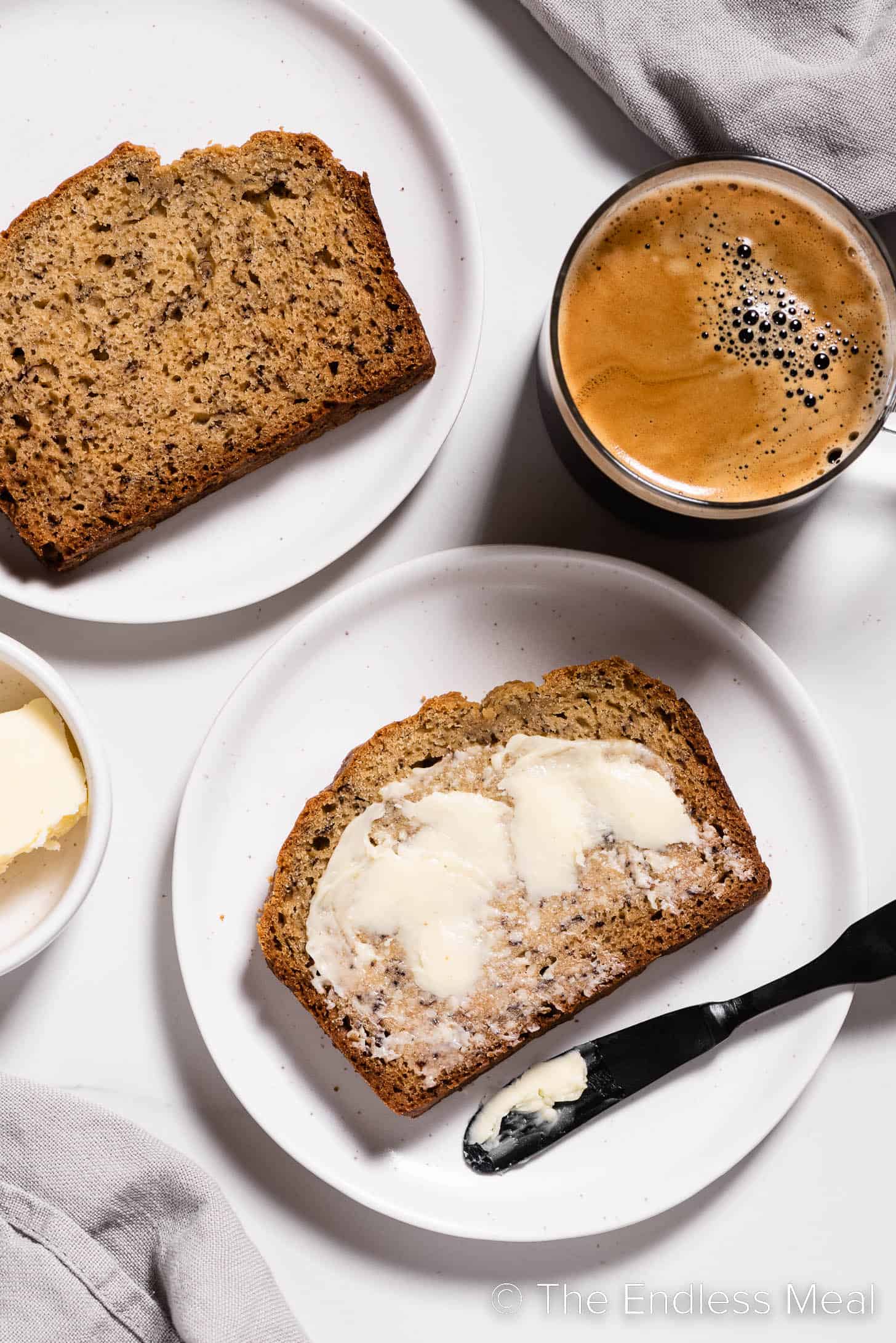 A buttered slice of banana bread made with buttermilk on a plate.