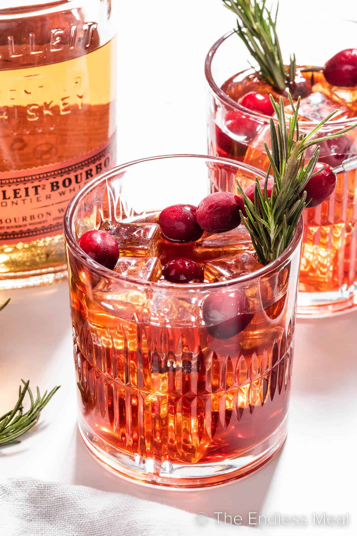 A Cranberry Bourbon Sour garnished with rosemary