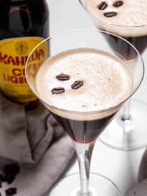 Two espresso martinis with a bottle of Kahlua.