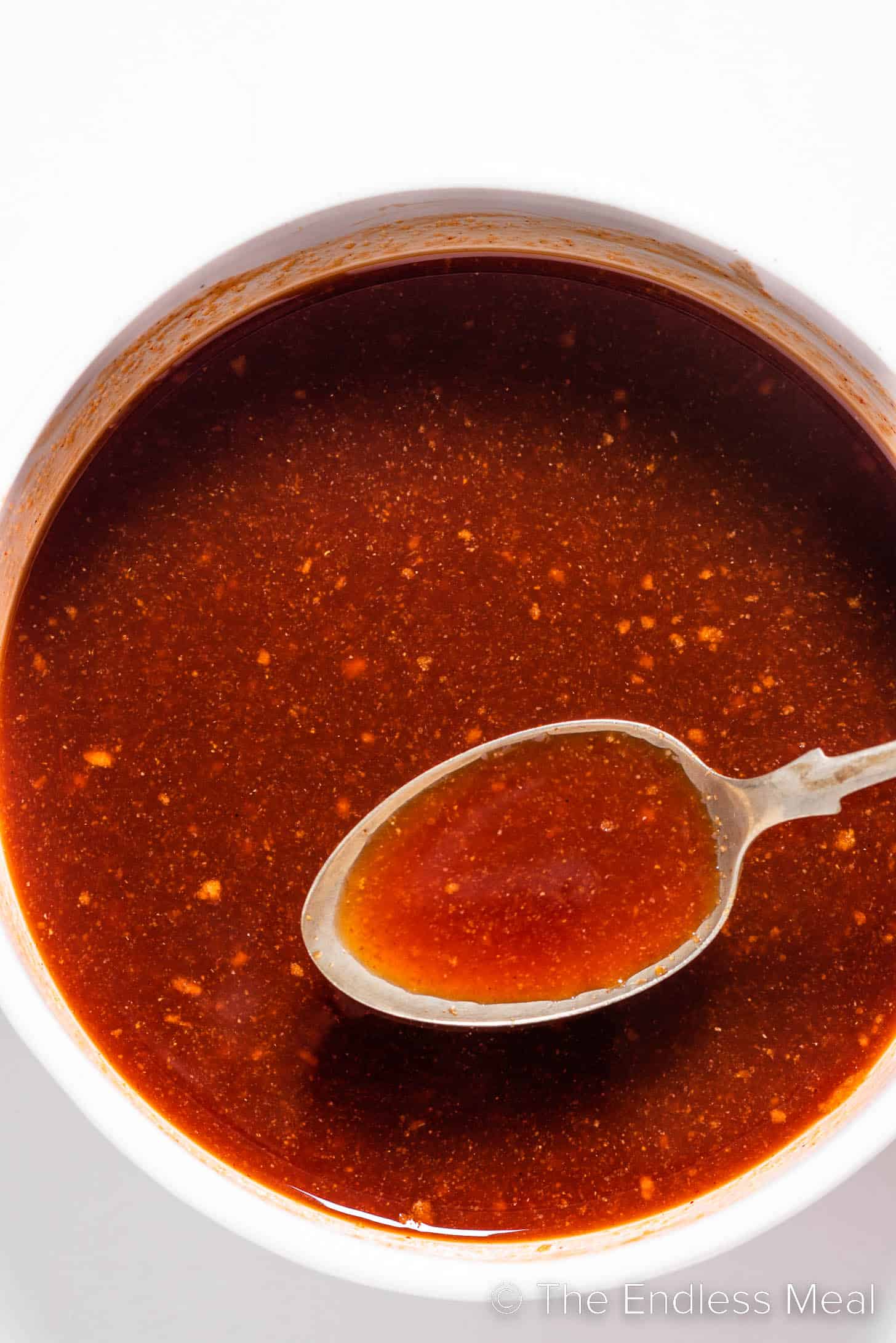 a spoon stirring Firecracker Sauce in a bowl