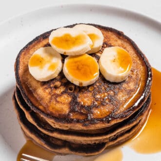 a stack of Whole Wheat Pancakes with bananas on top