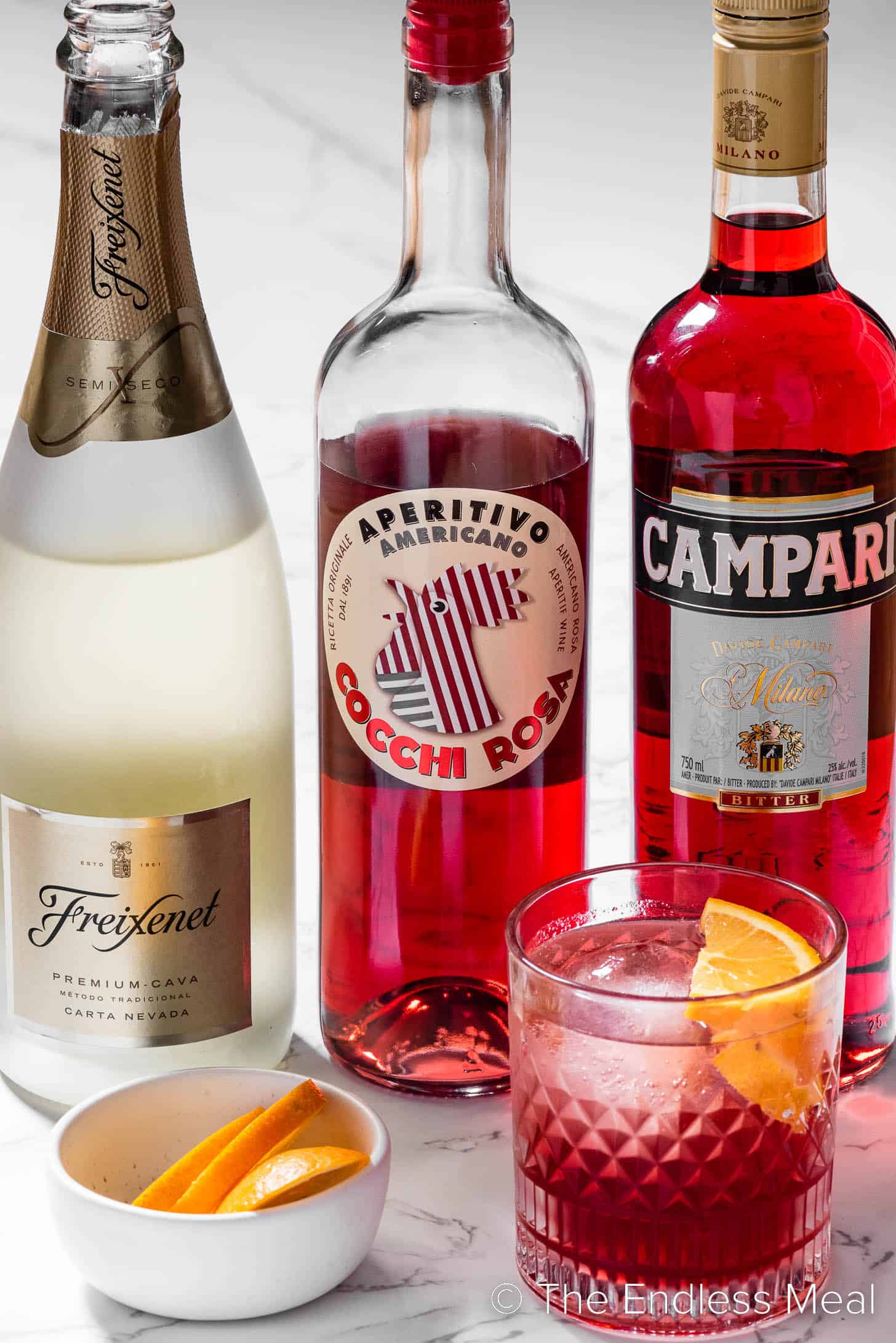 The ingredients needed to make a Negroni Sbagliato cocktail with prosecco
