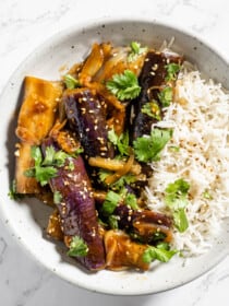 a close up of this Asian braised eggplant on a plate with rice.