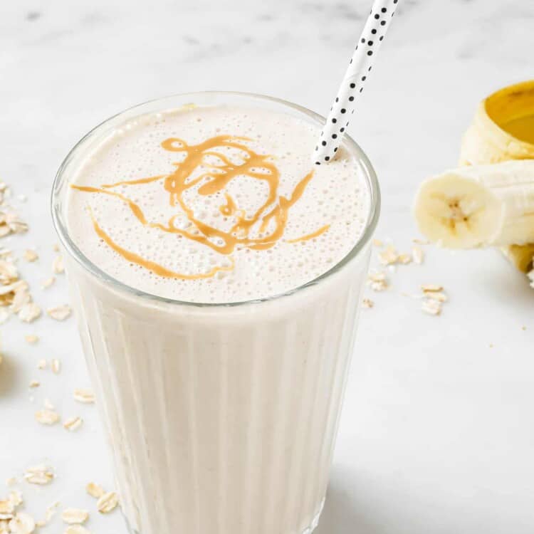 A Banana Bread Smoothie in a glass with a straw.