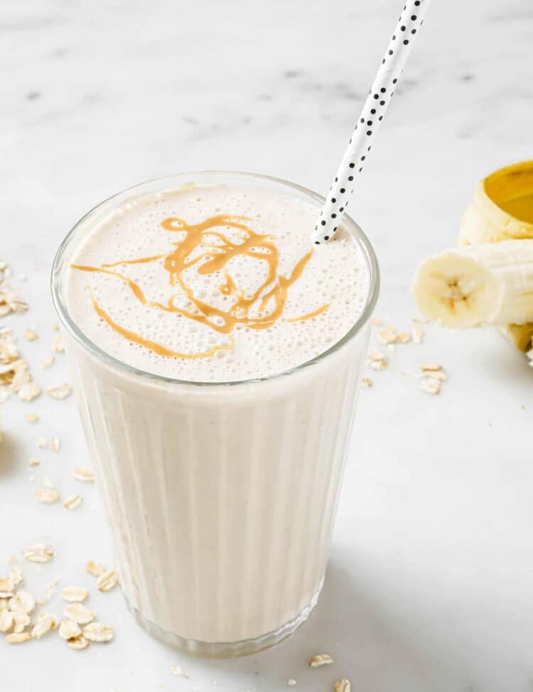 A Banana Bread Smoothie in a glass with a straw.