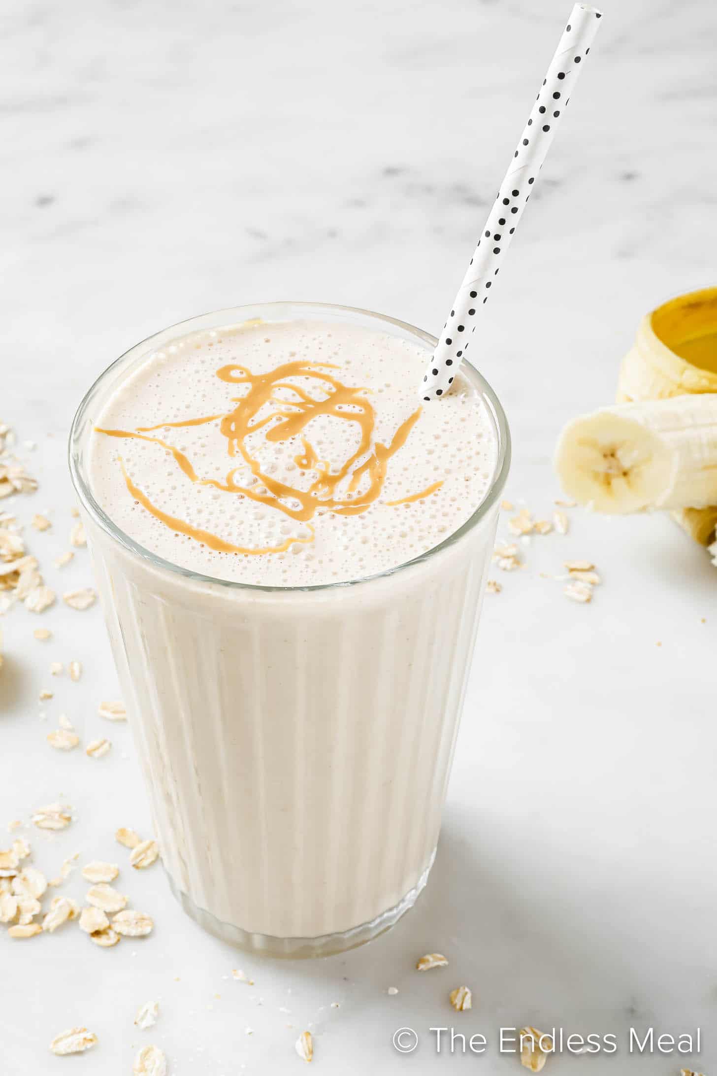 A Banana Bread Smoothie in a glass with a straw. 