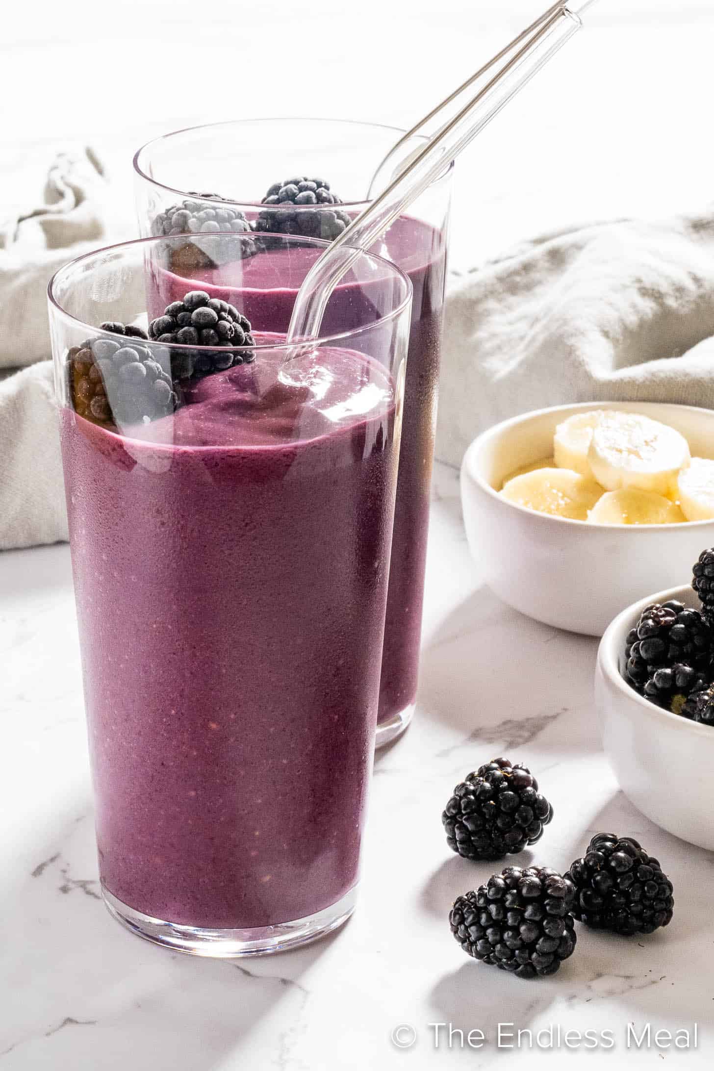 A Blackberry Smoothie with a straw for breakfast.