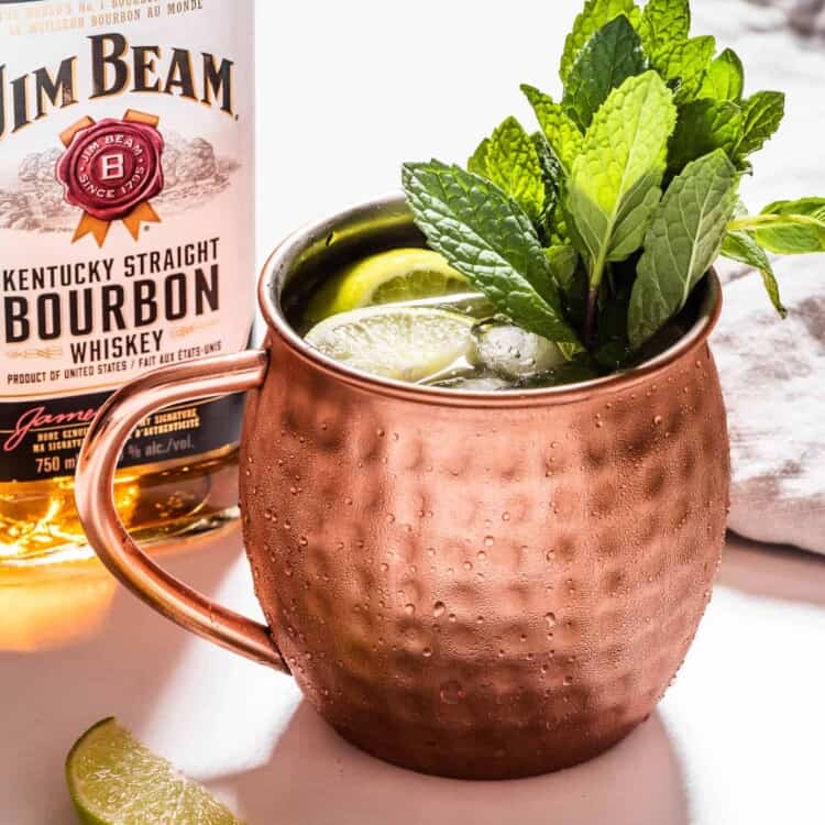 A Bourbon Mule next to a bottle of bourbon