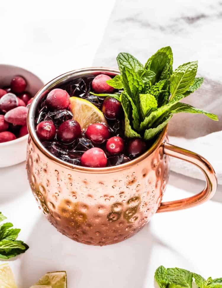 A festive cranberry mule in a copper mug