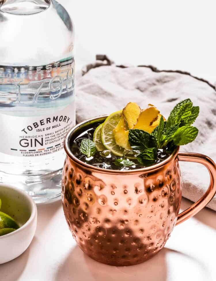 A Gin Mule next to a bottle of gin