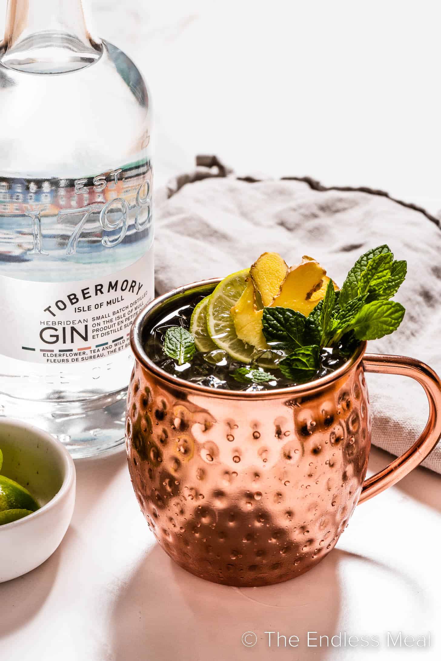 A Gin Mule next to a bottle of gin