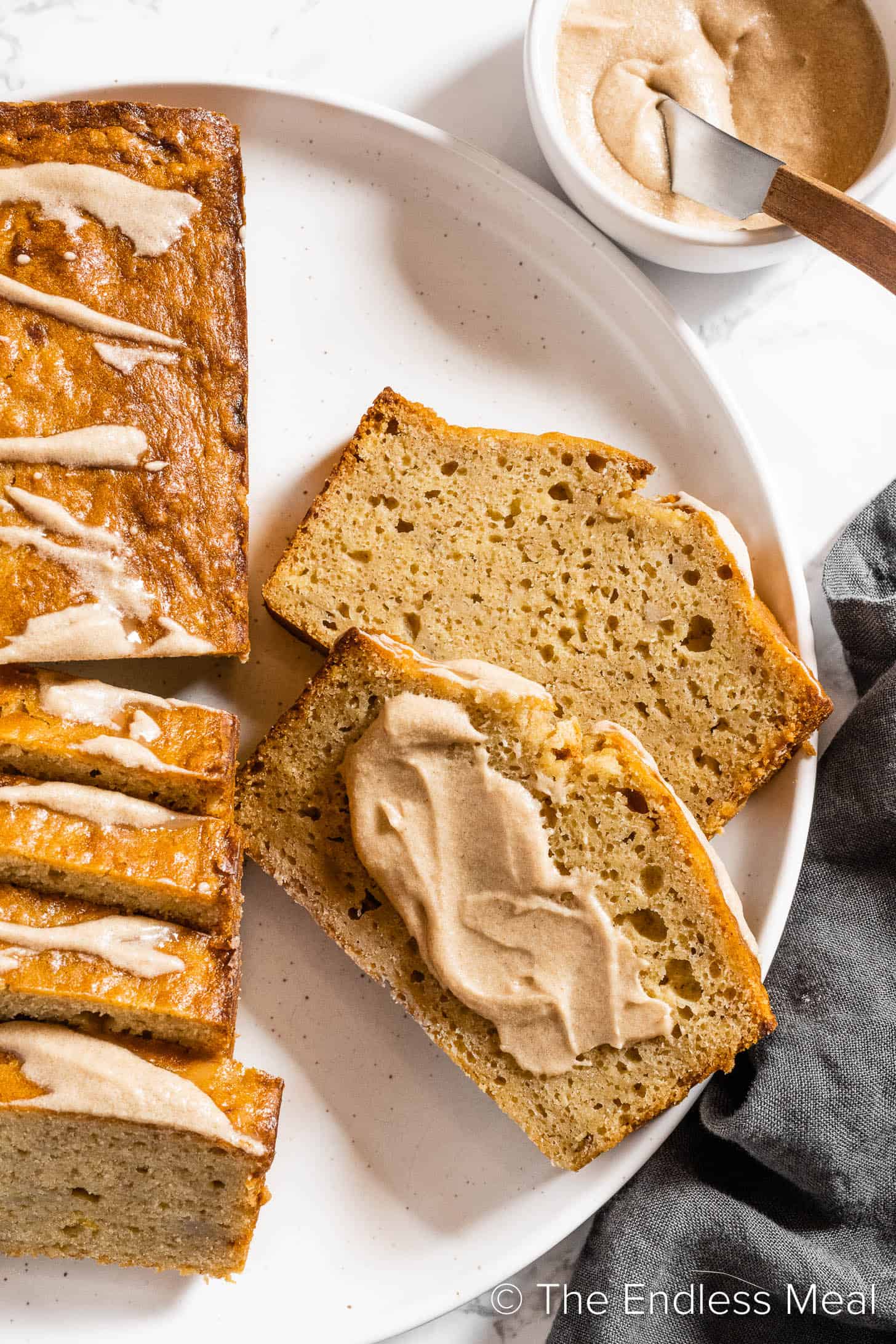 Two slices of Brown Butter Banana Bread topped with brown butter frosting