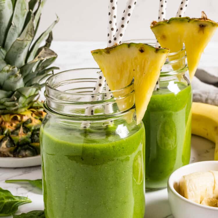 Two Green Breakfast Smoothies with pineapple garnish